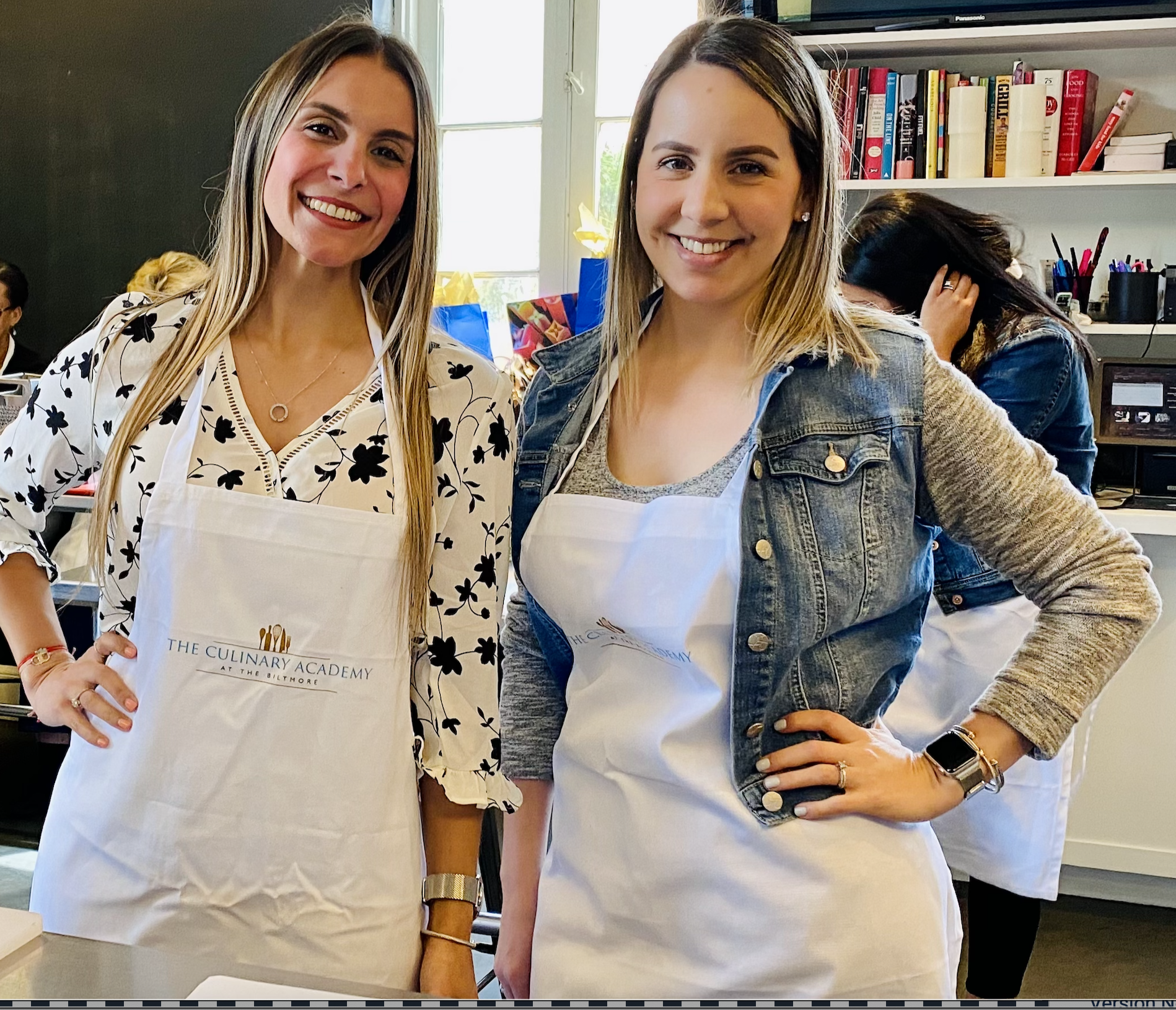 Rubenstein Law Employees Silu & Amanda smiling at camera during a cooking class from the employee retreat